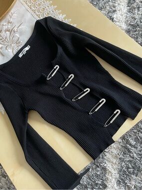 IMMODEL ribbed knit long-sleeve cardigan featuring safety pin closures.